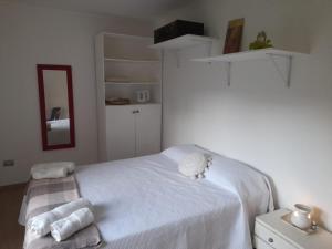 a bedroom with a white bed with towels on it at Habitación en casa familiar "FILOMENA" in Puerto Madryn