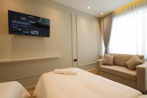 a hotel room with a bed and a couch and a tv at Dion Boutique Hotel - City Center in Krujë