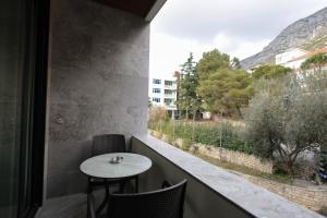 a balcony with a table and chairs and a window at Dion Boutique Hotel - City Center in Krujë