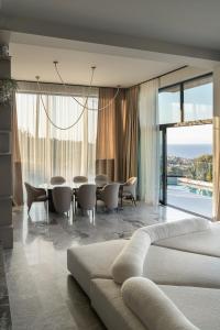 a living room with a couch and a table and chairs at Alicanto K1 in Polychrono