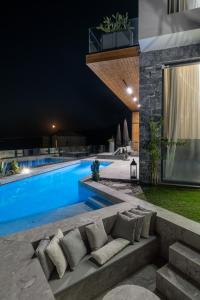 a swimming pool at night with a couch next to it at Alicanto K1 in Polychrono
