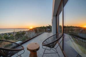 a patio with two chairs and a table on a balcony at Alicanto K1 in Polychrono