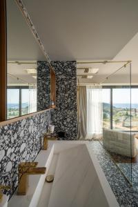 a bathroom with a large white tub in a room at Alicanto K1 in Polychrono +10 photos