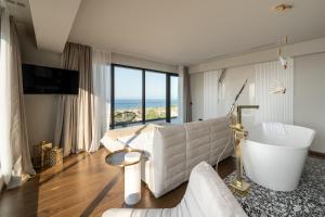 a living room with a tub and a large window at Alicanto K1 in Polychrono