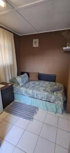 a bedroom with a bed with a blue comforter at Clay Stone Cottage in Goodwood