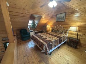 a bedroom with a bed and a chair in a cabin at Ducks Nest Retreat- Close to Ocoee river in Turtletown