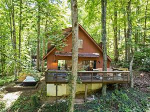 a house in the woods with a wrap around deck at Kabin Kleighp Maggie Valley in Maggie Valley