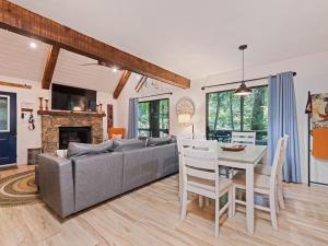 a living room with a couch and a table and a dining room at Kabin Kleighp Maggie Valley in Maggie Valley