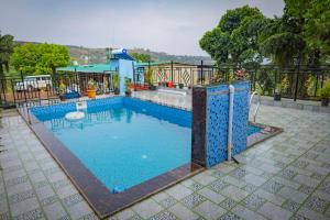 a swimming pool with a fence around it at X Western Hills panchagani in Panchgani