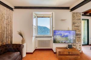 a living room with a couch and a large window at Stunning lake view, Cernobbio in Cernobbio