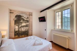 a bedroom with a large white bed and a window at Stunning lake view, Cernobbio in Cernobbio