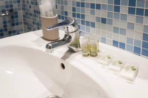 a bathroom sink with a faucet and two bottles on it at Stunning lake view, Cernobbio in Cernobbio +26 photos