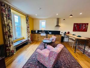a living room with two chairs and a table at Black Isle Bar Apartment in Fort William
