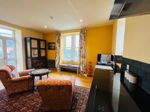 a living room with yellow walls and a kitchen at Black Isle Bar Apartment in Fort William