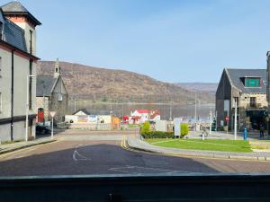 an empty street in a town with a mountain at Black Isle Bar Apartment in Fort William