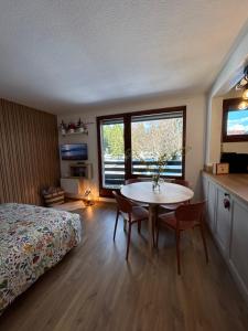a bedroom with a bed and a table with chairs at Le Charme du Gaschney in Muhlbach-sur-Munster