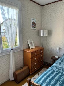 a bedroom with a bed and a dresser and a window at Maison ALCEMA in Carentan