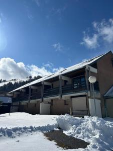 a building with a lot of snow in front of it at Le Charme du Gaschney in Muhlbach-sur-Munster