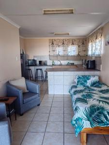 a living room with a couch and a kitchen at Lighthouse Studio in Doring Bay