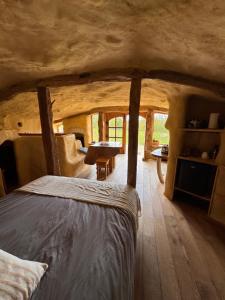 a bedroom in a log cabin with a bed at Maison Terre Les Cabanes de Fallot - sauna bain-froid piscine naturelle in LʼIsle-Bouzon