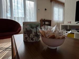 a table with a bowl of bread on top of it at Maison ALCEMA in Carentan
