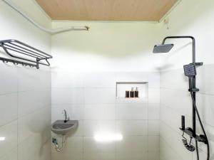 a white bathroom with a sink and a shower at La Casa de Maria in Komodo Labuan Bajo Airport