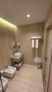 a bathroom with a sink and a toilet and towels at Dion Boutique Hotel - City Center in Krujë