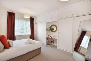 a white bedroom with a bed and a chair at Spacious Gate 3BR City 5mins Walk Pets Welcome in Hereford