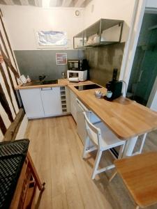 a small kitchen with a wooden counter and a table at Le Petit Cocon d'Orléans in Orléans +12 photos