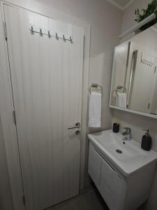 a bathroom with a white door and a sink at Luna apartman in Čačak +21 photos