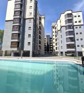 a swimming pool in front of two tall buildings at Nivaro Homes in Nakuru