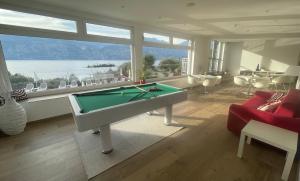 a living room with a pool table and a large window at Hotel Roma Aparthotel in Malcesine