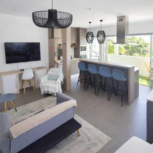 a living room with a couch and a bar with chairs at RayGrass, La Gaulette in La Gaulette