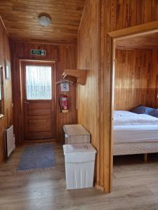 a small room with a bed and a door at Ekra Cottages in Lagarfljótsvirkjun