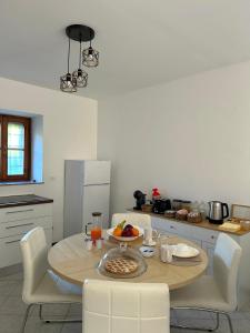 a kitchen with a wooden table with chairs and a tableasteryasteryasteryasteryastery at Il Nido sul Lago B&B in Viverone