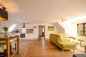 a living room with a yellow couch and a table at Freya in Goltoft