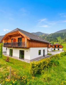 a large white house with a wooden roof at Chalet Rattendorf 139 in Rattendorf