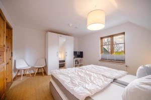 a white bedroom with a bed and a window at Freya in Goltoft