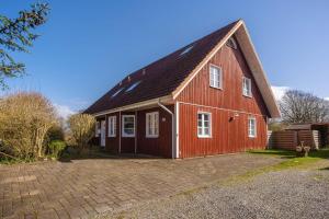 a red barn with a black roof at Freya in Goltoft