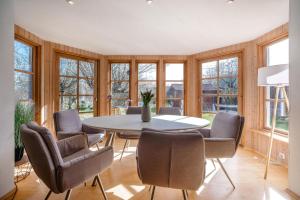 a dining room with a table and chairs and windows at Odin in Goltoft