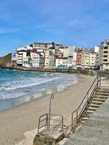 a beach with a bunch of buildings and the ocean at Puerto playa B in Malpica