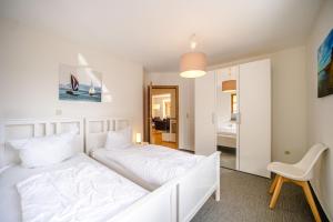 a bedroom with a white bed and a white chair at Odin in Goltoft