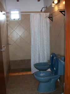 bagno con 2 servizi igienici blu e doccia di La Protegida a El Chalten