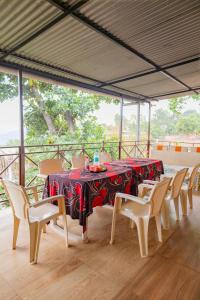 a table with chairs and a red table cloth on it at X Western Hills panchagani in Panchgani