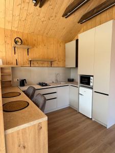 a kitchen with white cabinets and a wooden ceiling at Nest house in Skole
