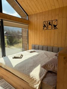 a bed in a room with a large window at Nest house in Skole