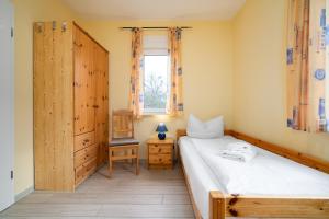 a bedroom with a bed and a window and a chair at Ferienwohnung Haus Vietzen 2 in Rechlin