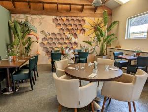 a restaurant with tables and chairs and plants at The Bee - Trekkershuts & Apartment in Opperdoes