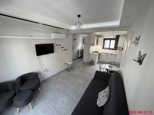 a living room with a couch and chairs and a tv at Erdem Apart D4 in Dalaman
