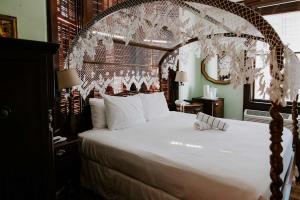 a bedroom with a large bed with an arched headboard at Curry Mansion Inn in Key West